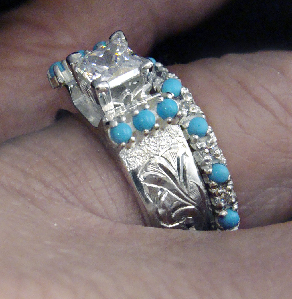 Silver ring with turquoise stones on a finger Cowboyjewelers